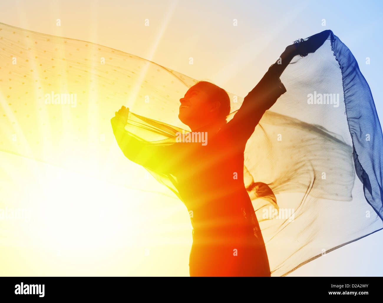 Indische Mädchen mit Schleier im Wind in Richtung der Sonne drehen. Silhouette Stockfoto