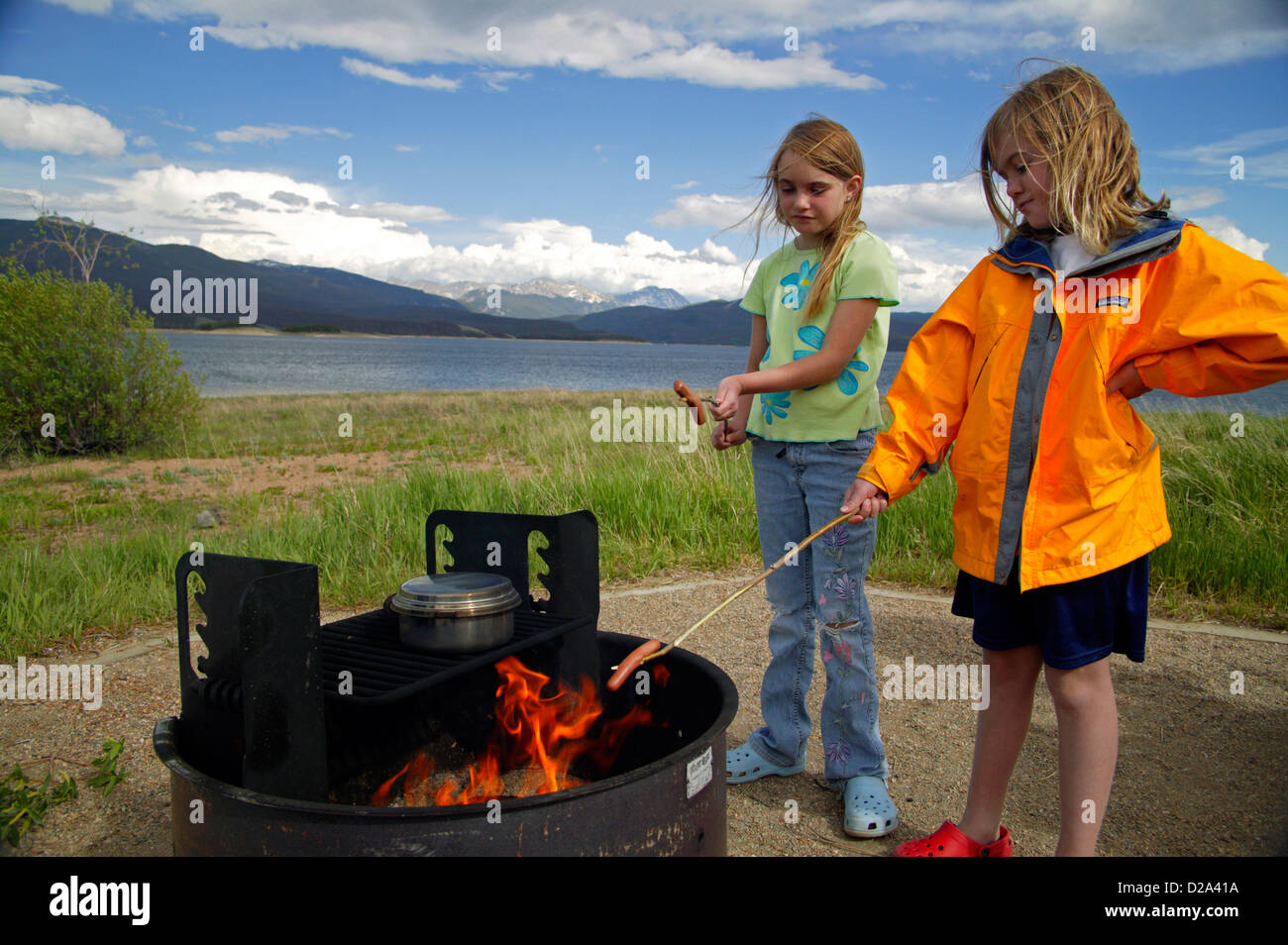 Colorado, Lake Granby. Zwei Mädchen Hot Dogs auf ein Lagerfeuer rösten. Stockfoto
