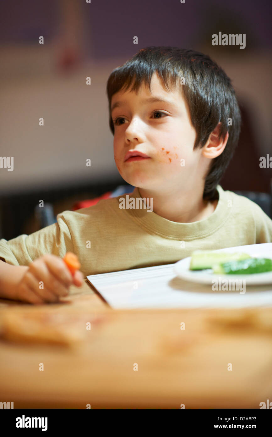 Junge am Tisch essen Stockfoto