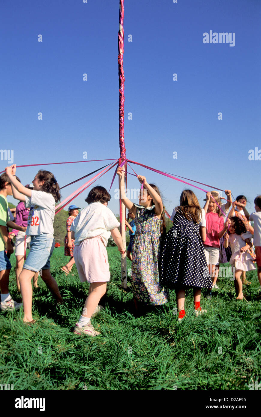 May Day. Kinder tanzen um den Maibaum. Stockfoto