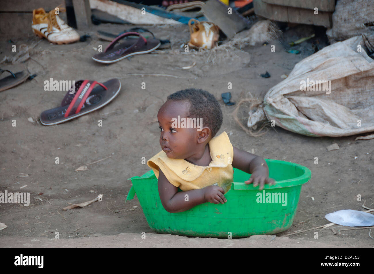 Namuwongo Slumgebiet, Kampala, wo VHTs (Dorf Gesundheitsteam) TB aufsuchende Drogenarbeit - Baby setzte sich in eine Plastikschüssel Stockfoto