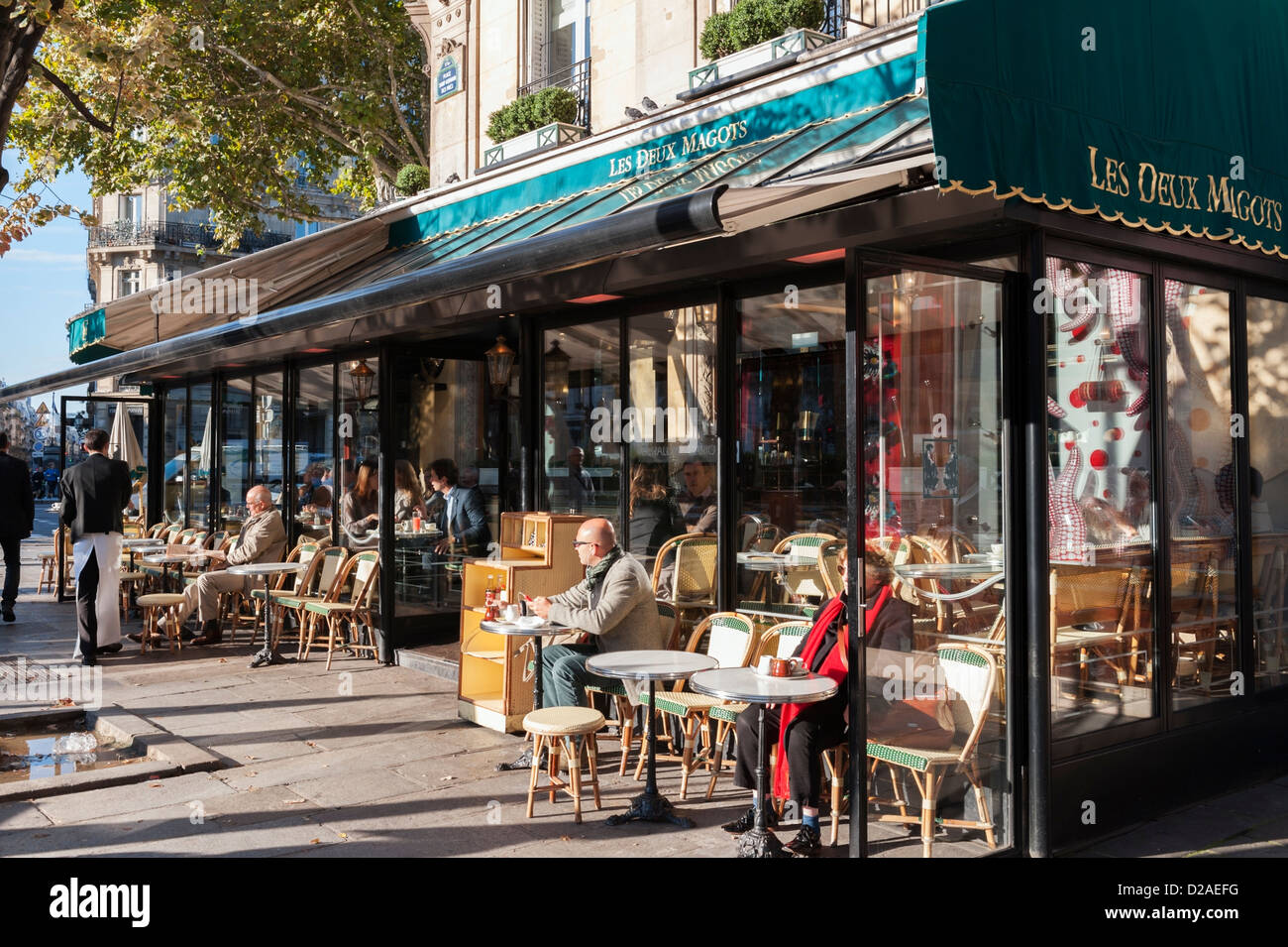 Kunden an einem sonnigen Herbstmorgen im berühmten Paris Café Les Deux Magots in Saint-Germain-des-Prés Stockfoto