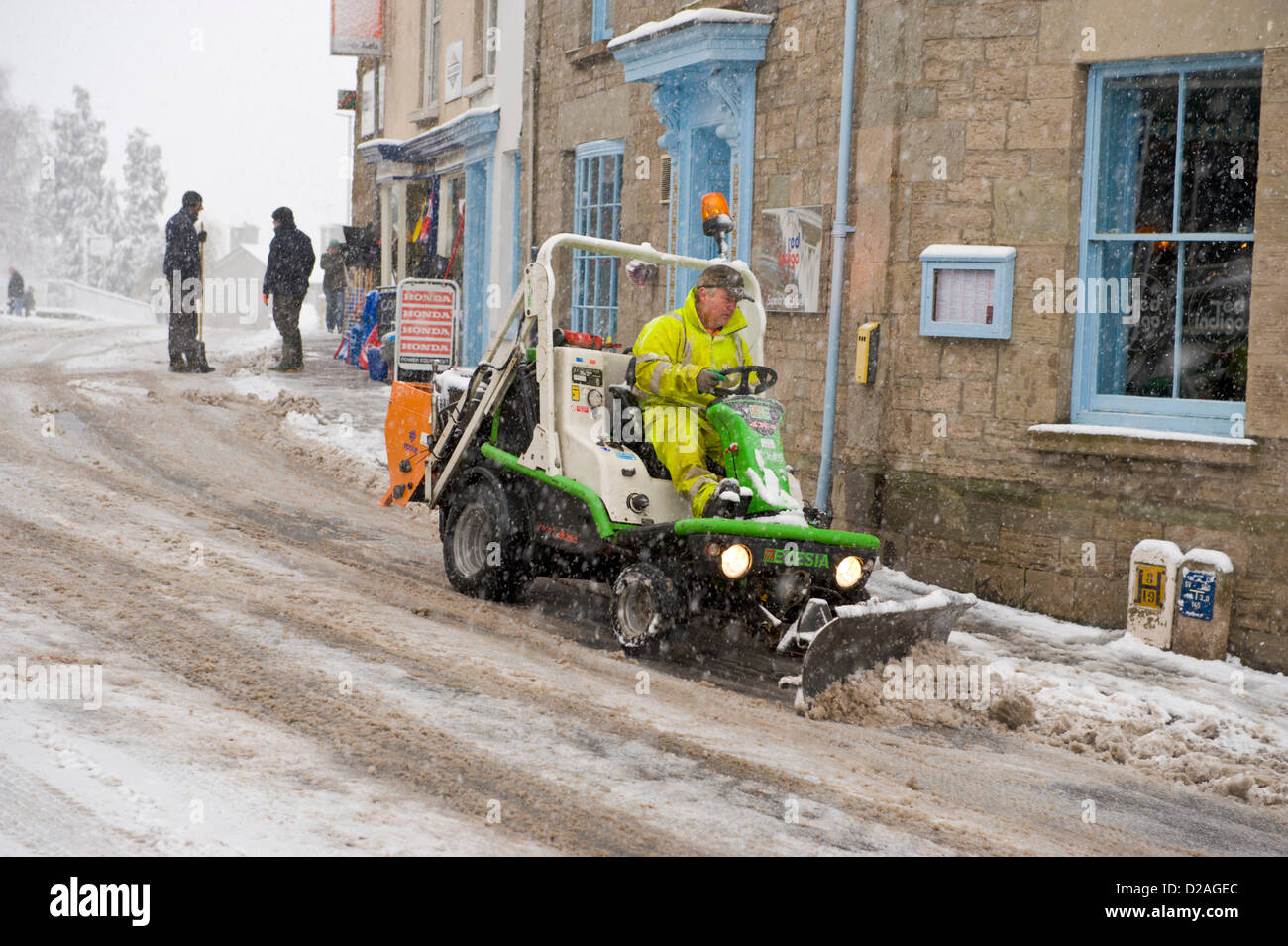 Powys County Council Arbeiter mit Mini-Schneepflug für knirschte und Schneeräumung von Straßen und Gehwegen nach starkem Schneefall. Hay-on-Wye Powys, Wales UK. 18. Januar 2013. Bildnachweis: Jeff Morgan/Alamy Live-Nachrichten Stockfoto