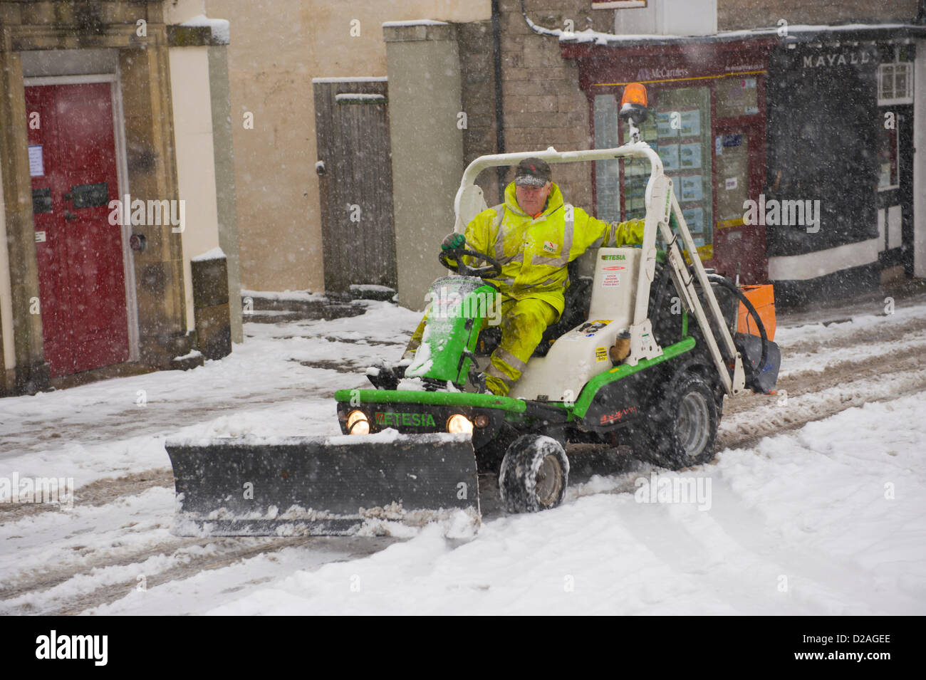 Powys County Council Arbeiter mit Mini-Schneepflug für knirschte und Schneeräumung von Straßen und Gehwegen nach starkem Schneefall. Hay-on-Wye Powys, Wales UK. 18. Januar 2013. Bildnachweis: Jeff Morgan/Alamy Live-Nachrichten Stockfoto