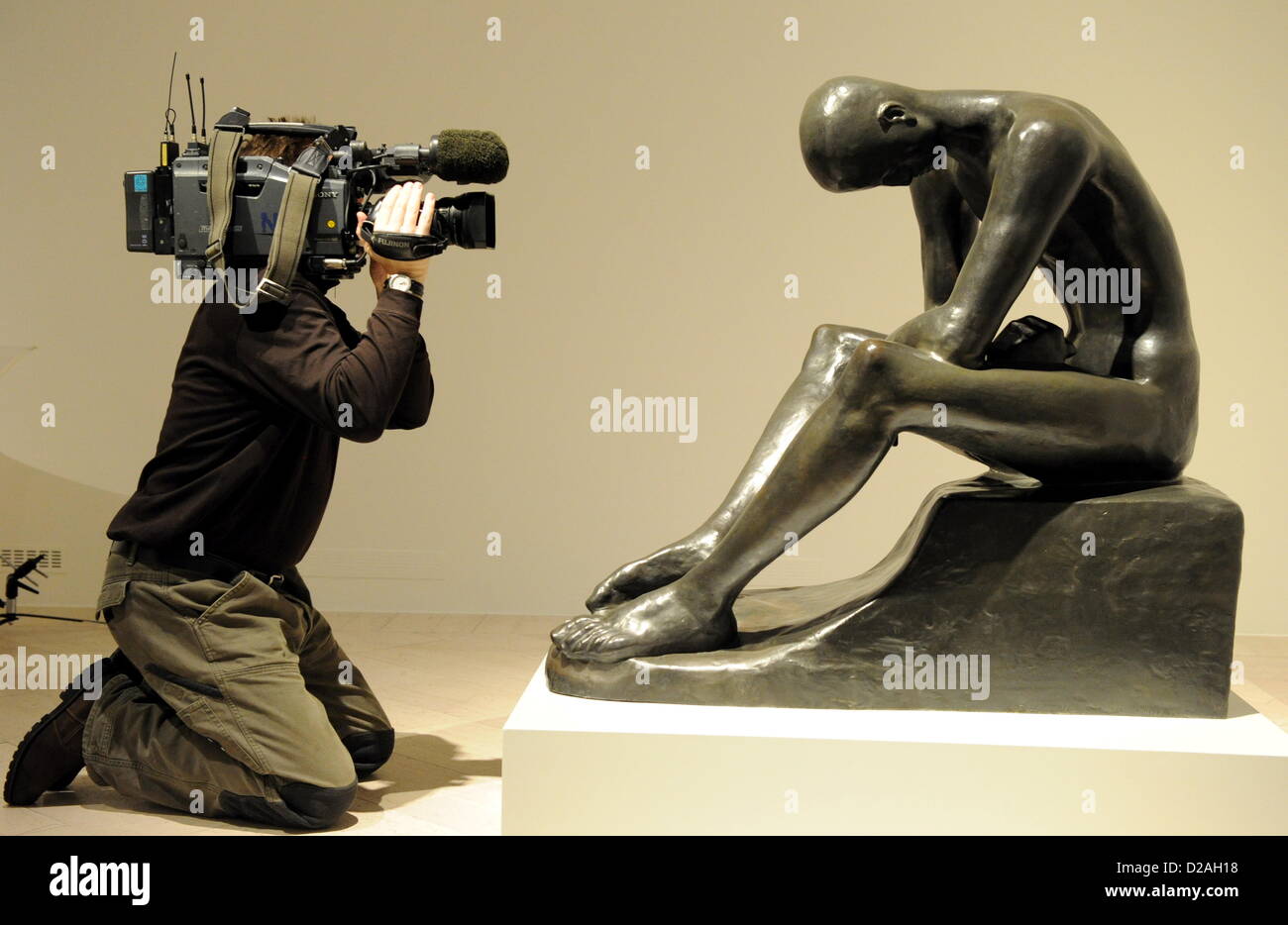 Ein Kameramann filmt die Bronzeskulptur "Sitzt Jugend" von Wilhelm Lehmbruck (1881-1919) in Schleswig, Deutschland, 18. Januar 2013. Die Ausstellung im Schloss Gottorf, die 120 Werke des berühmten deutschen Bildhauers zeigt, läuft vom 20 Januar bis 21. April 2013. Foto: Carsten Rehder Stockfoto