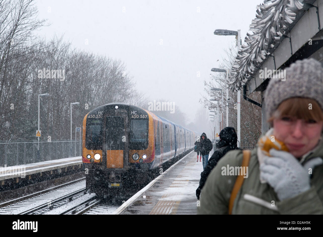 S-Bahn nähert sich einem s-Bahnhof im Schnee. Stockfoto