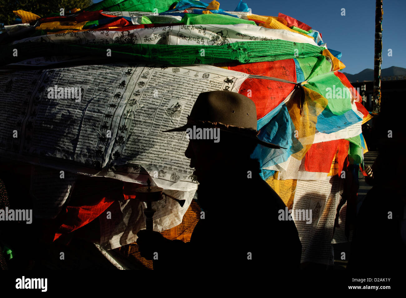 ein Pilger mit einem Gebet Glöckchen vorbei Gebet Fahnen, Lhasa, tibet Stockfoto