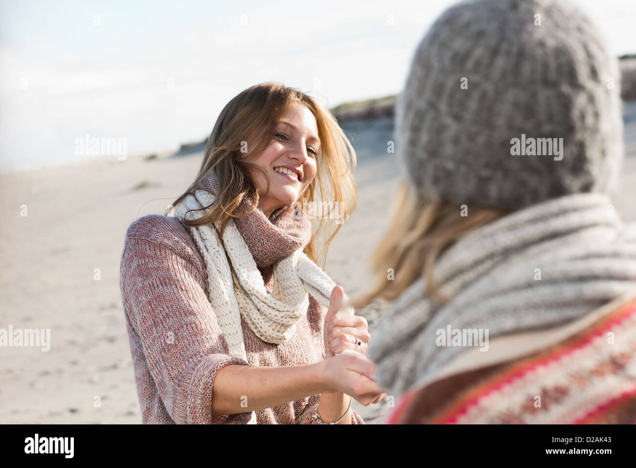 Lächelnde Frauen spielen am Strand Stockfoto