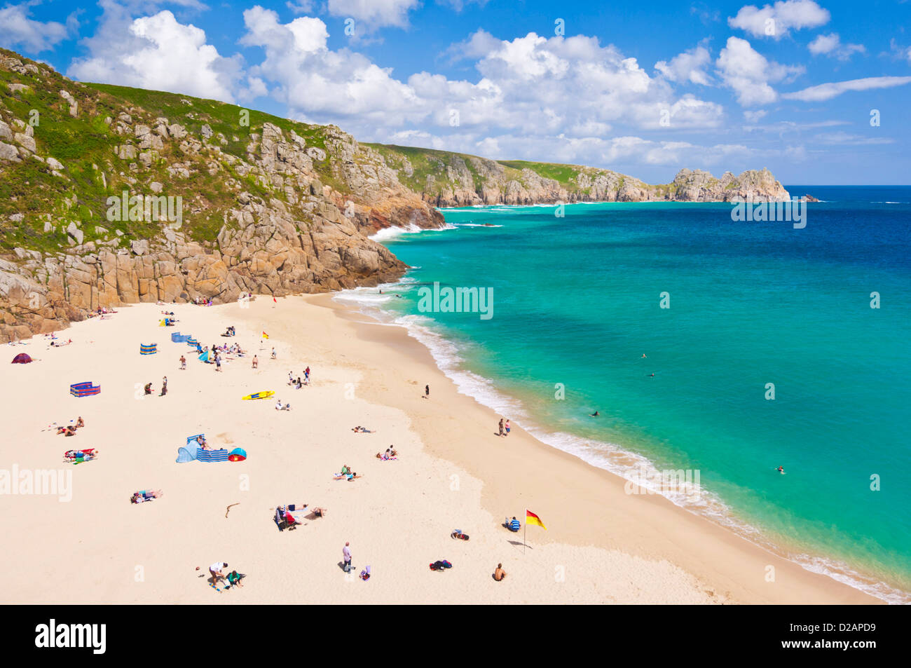 Urlauber, die zum Sonnenbaden am Strand von Porthcurno an einem Sommertag Cornwall England GB UK EU Europa Stockfoto
