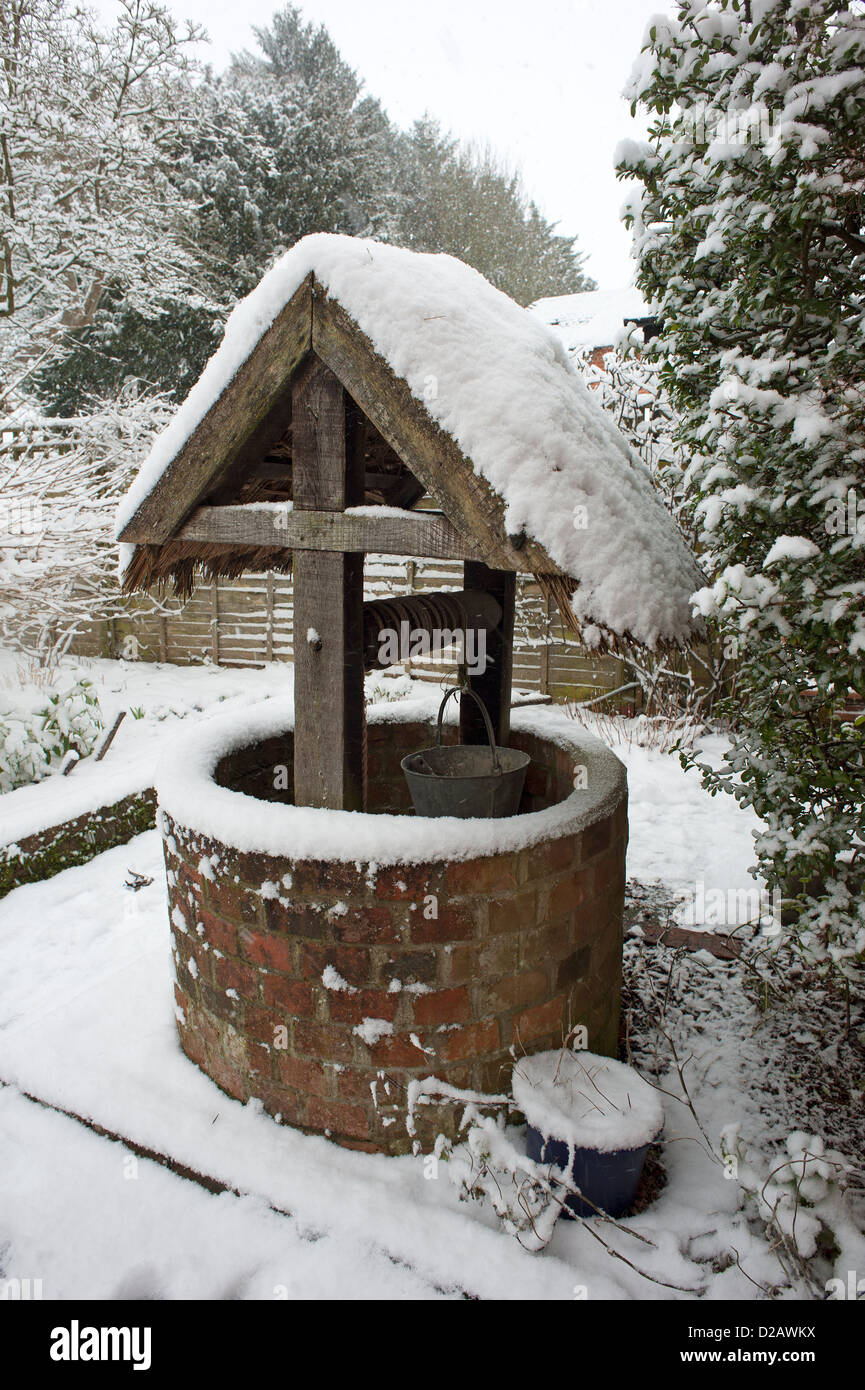 Reetgedeckte gut abgedeckt im Schnee in einem Hampshire Garten England UK Stockfoto