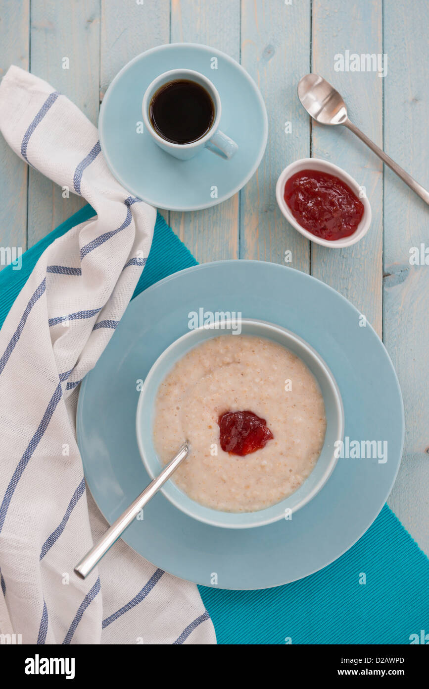 Porridge zum Frühstück, mit Kaffee und Marmelade. Stockfoto