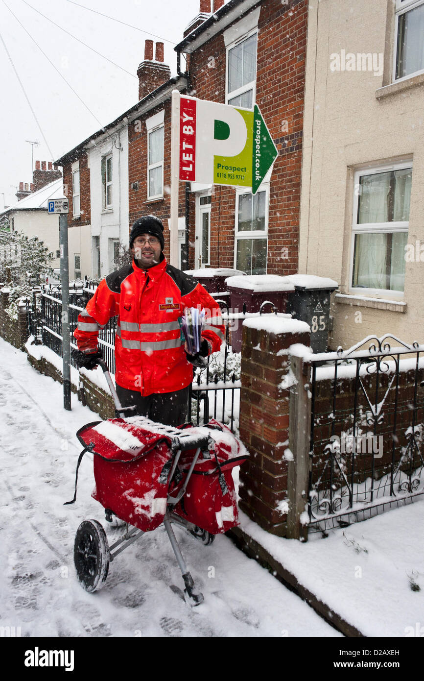 Royal Mail Postbote liefert Mail an verschneiten Wintertagen. Reading, Berkshire, England, UK. Stockfoto