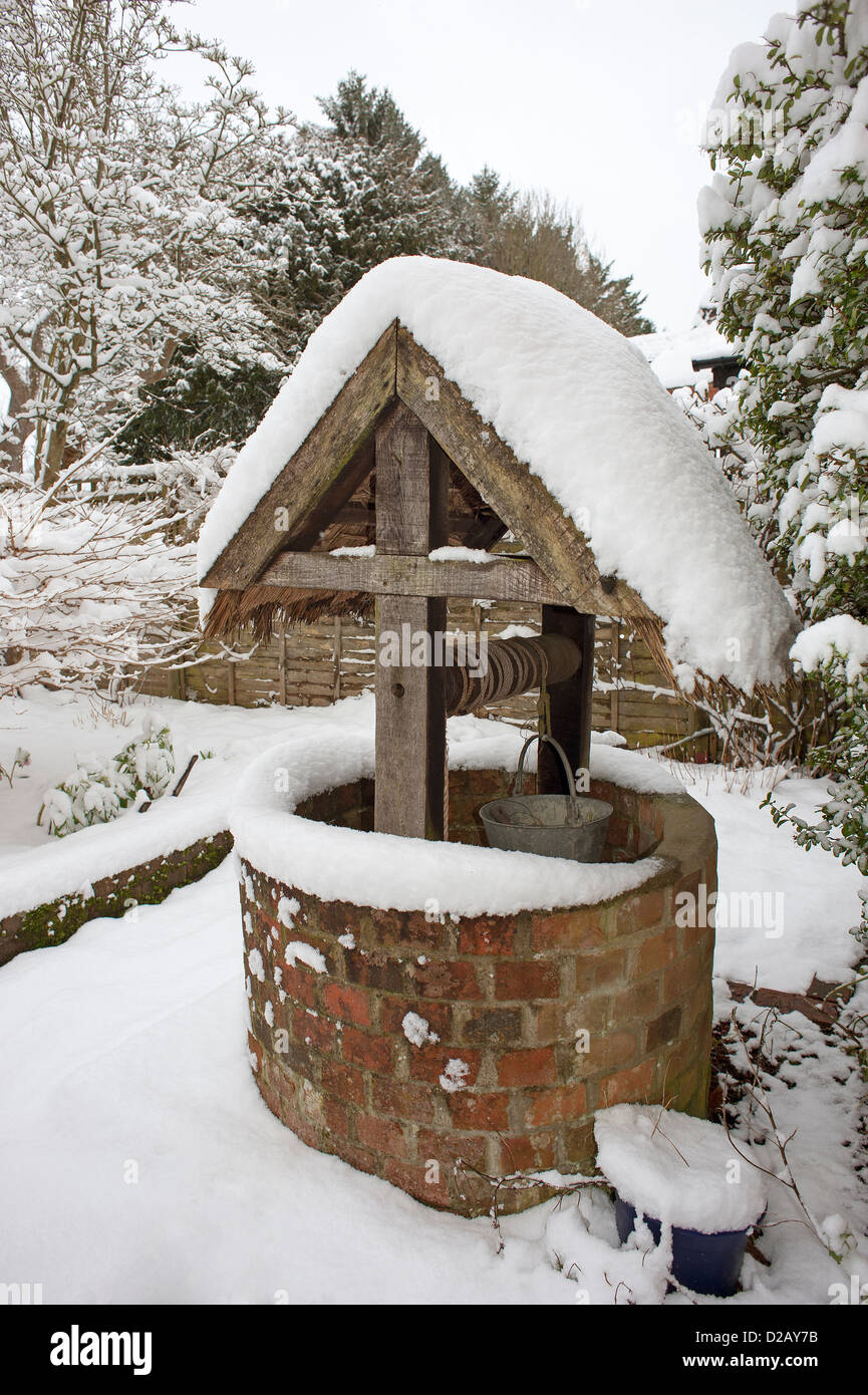 Reetgedeckte gut abgedeckt im Schnee in einem Hampshire Garten England UK Stockfoto