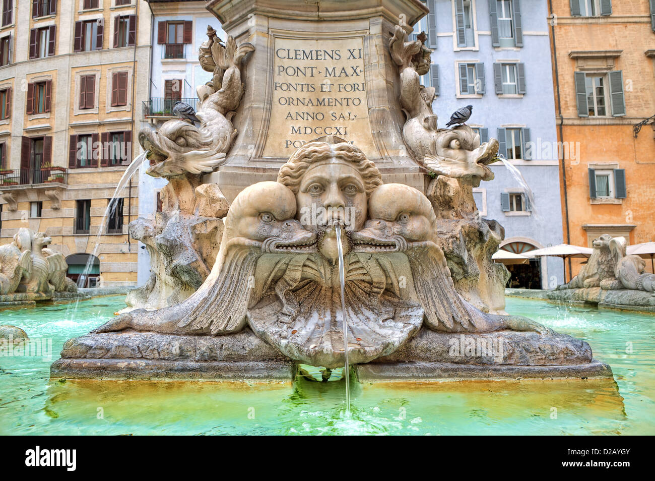 Fragment des berühmten Brunnen des Pantheon und traditionellen römischen Häusern auf Hintergrund in Rom, Italien. Stockfoto