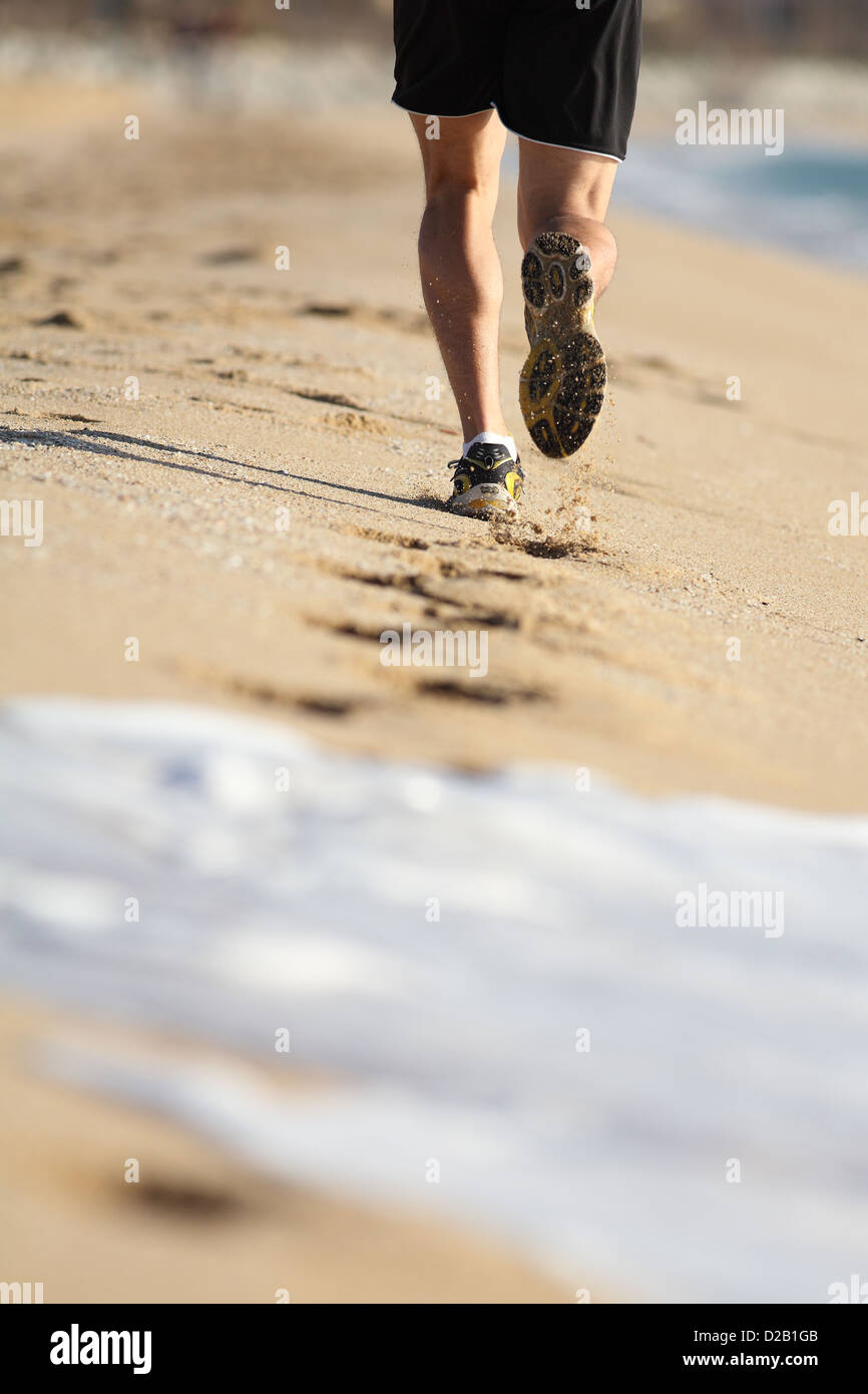 Mann Beine laufen auf dem Sand des Strandes mit Wasser löschen Spuren Stockfoto