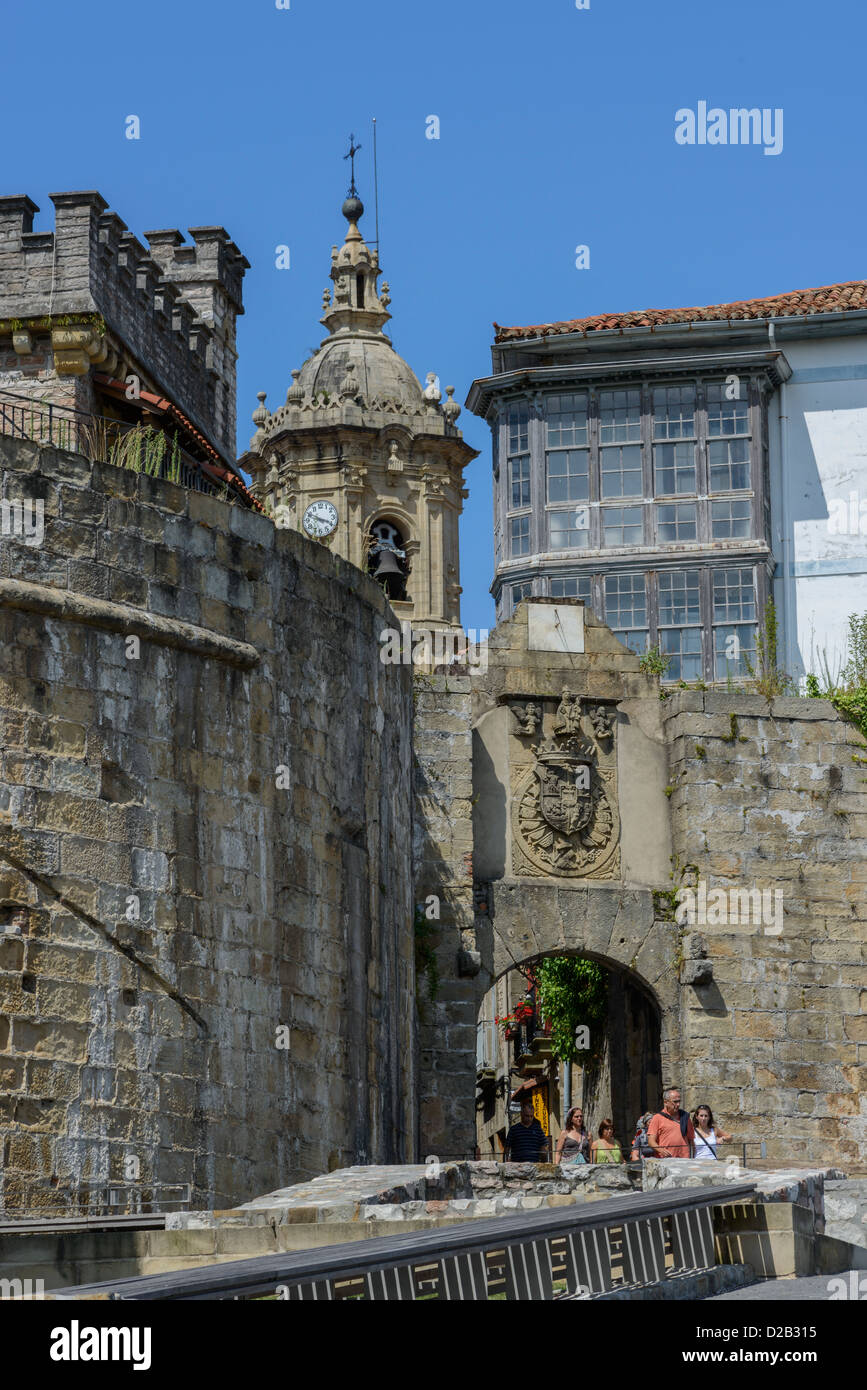 Eingang durch die Stadtmauer in Hondarribia (Pais Baskenland, Spanien). Blues Himmel und Kirchturm auf Rückseite. Stockfoto