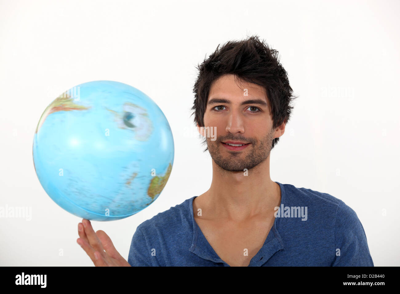 Man dreht einen Globus an seinen Fingerspitzen Stockfoto