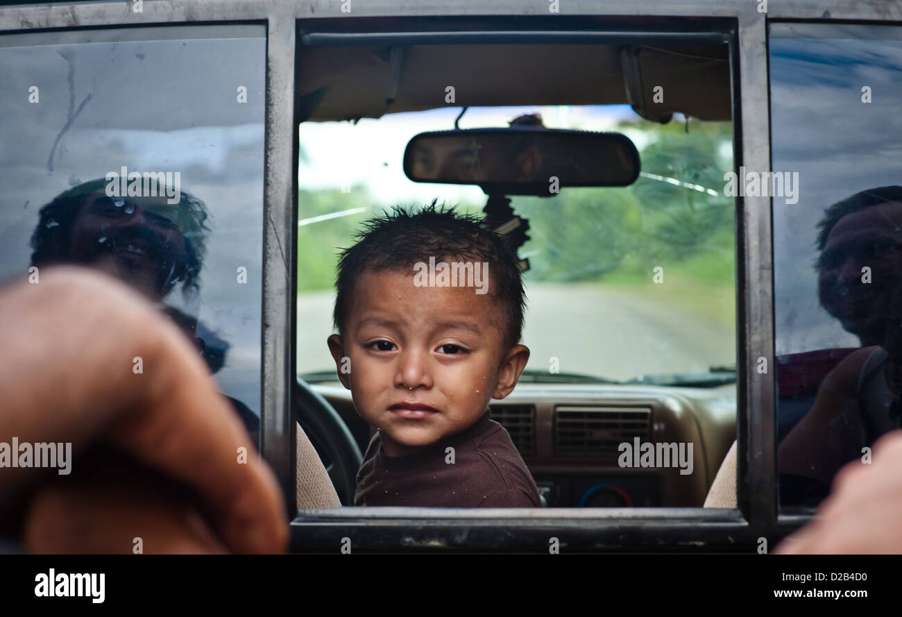 Dies ist ein Bild eines kleinen Jungen auf der Suche auf der Rückseite eines Pick-up in Belize. Stockfoto