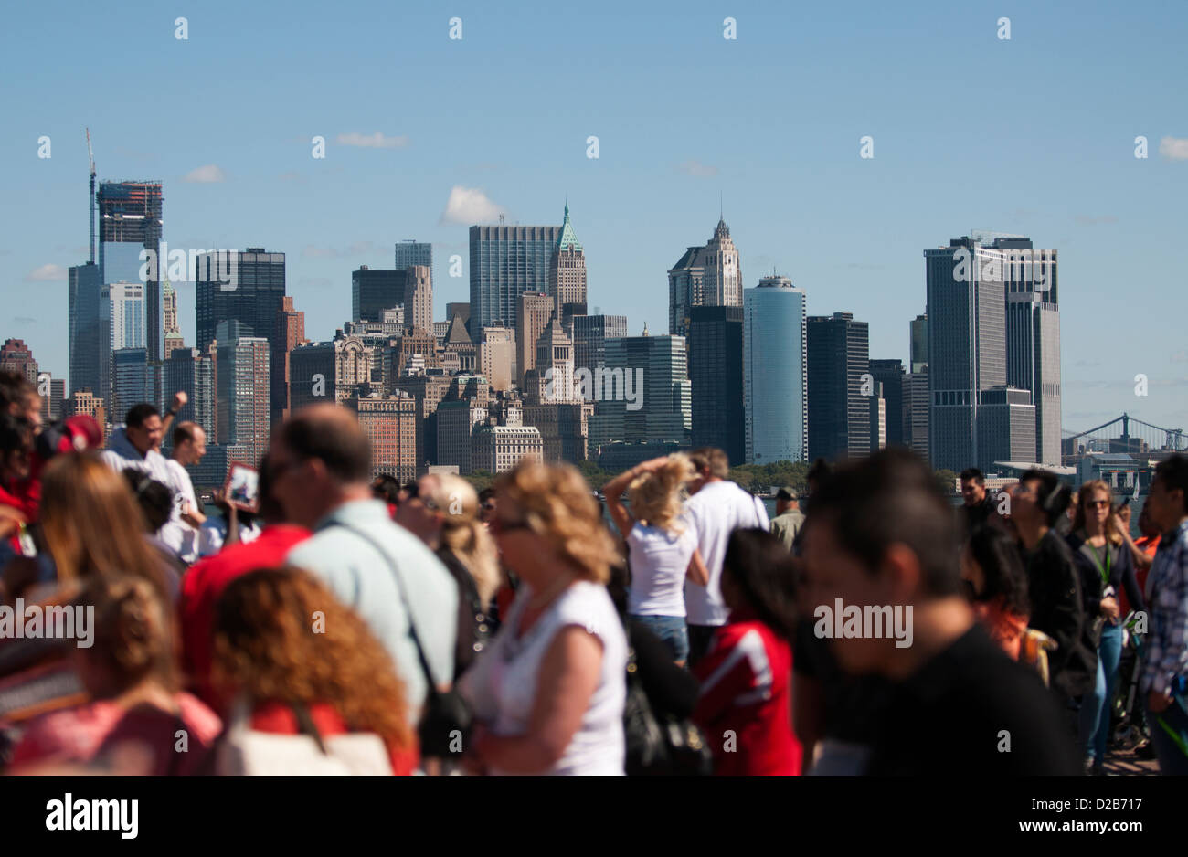 Lower Manhattan angesehen durch Touristen im Blick auf die Freiheitsstatue auf Liberty Island. Stockfoto