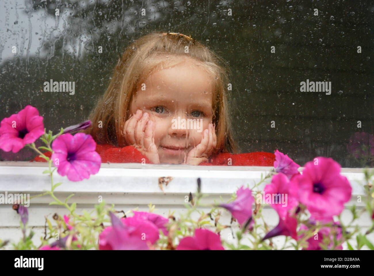 4 Jahre altes Mädchen suchen Fenster an regnerischen Tag In Massachusetts. Stockfoto