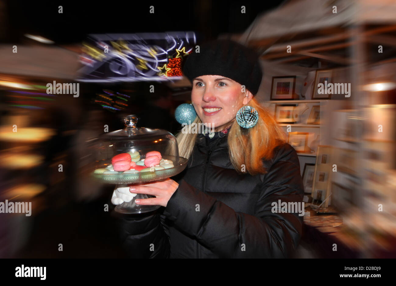 Eine Frau, die verkaufen ihre Ware am Straßenmarkt in Aberdeen, Schottland, zu Weihnachten mit Kugeln für Ohrringe Stockfoto