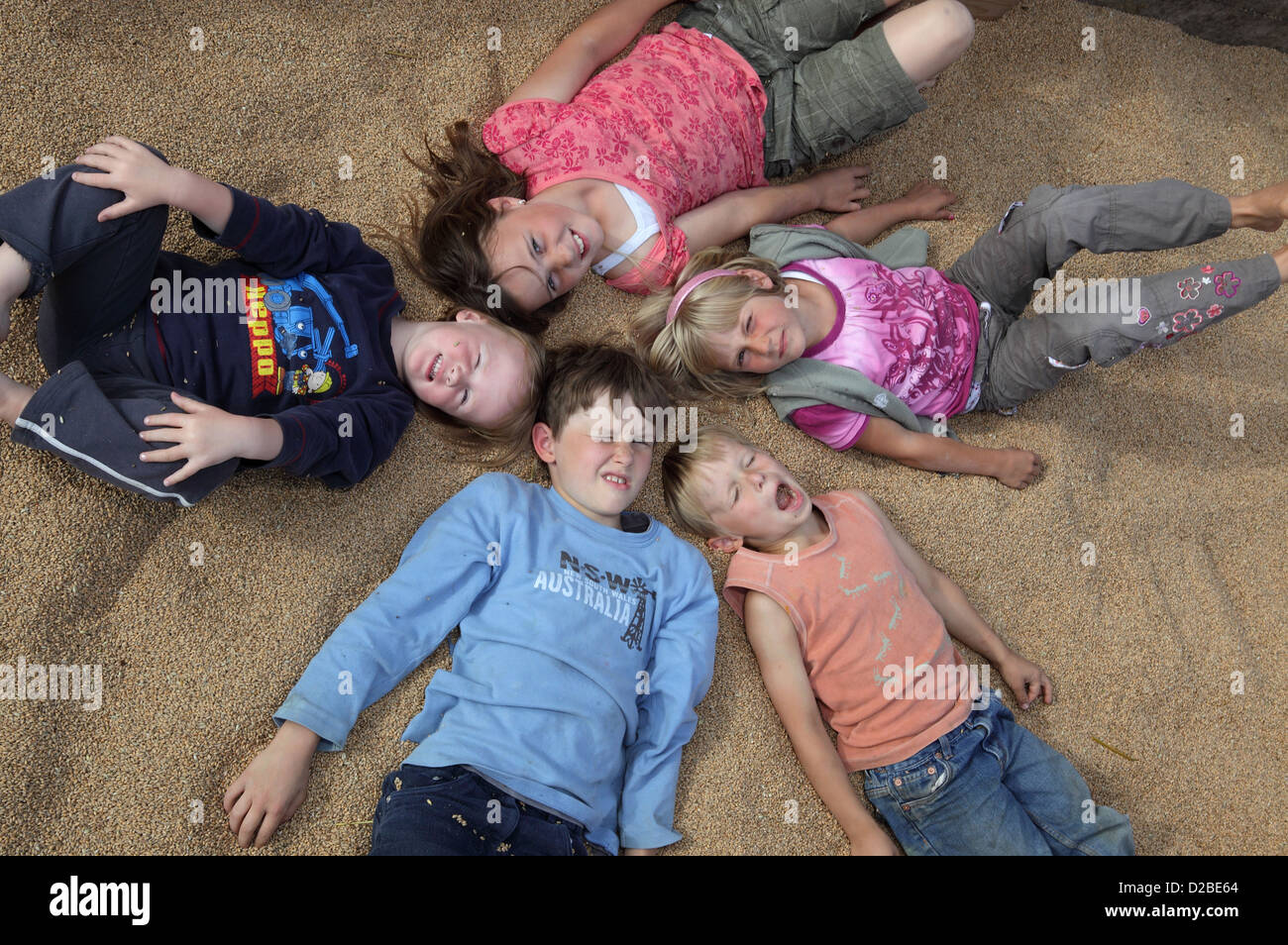Glänzend, Deutschland, Dorfkinder liegen auf Weizenkoernern Stockfoto