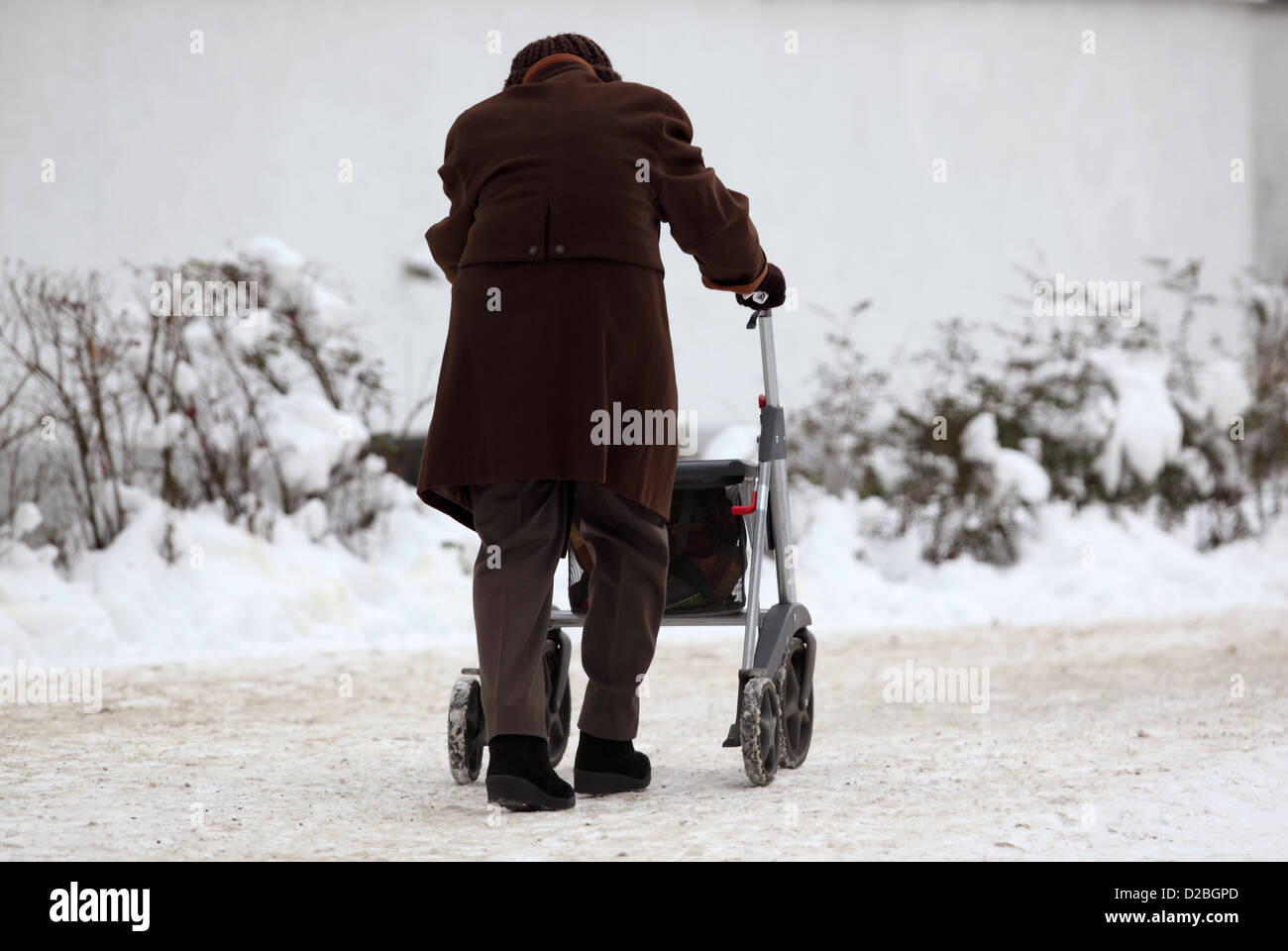 Berlin, Deutschland, Senioren mit Walker einen verschneiten Bürgersteig entlang läuft Stockfoto
