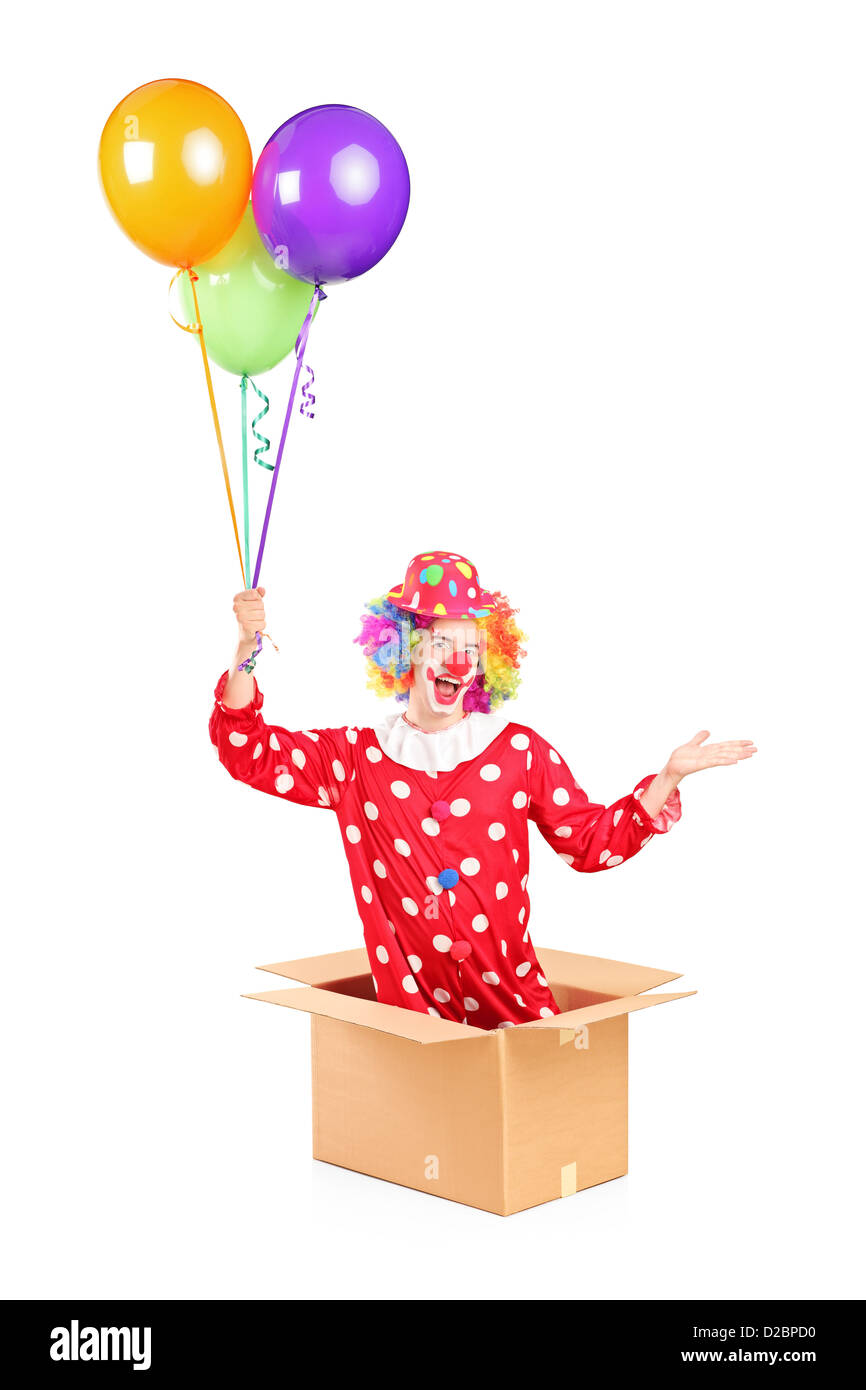 Männlichen Clown in einem Karton mit Haufen Luftballons isoliert auf weißem Hintergrund Stockfoto