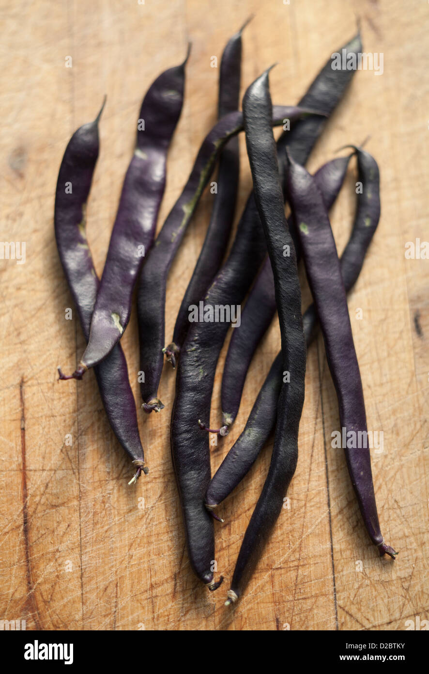 Bio schwarze farbige Wein Frische Stangenbohnen auf ein Schneidebrett Stockfoto