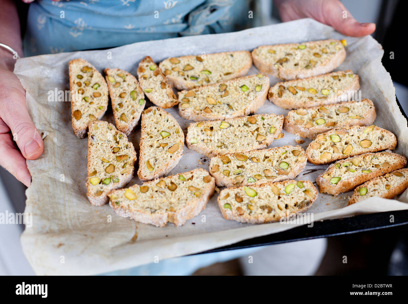 Biscotti. Pistazien gewürzt nach Hause gebackene Kekse auf ein Hand-held Backblech frisch aus dem Ofen Stockfoto