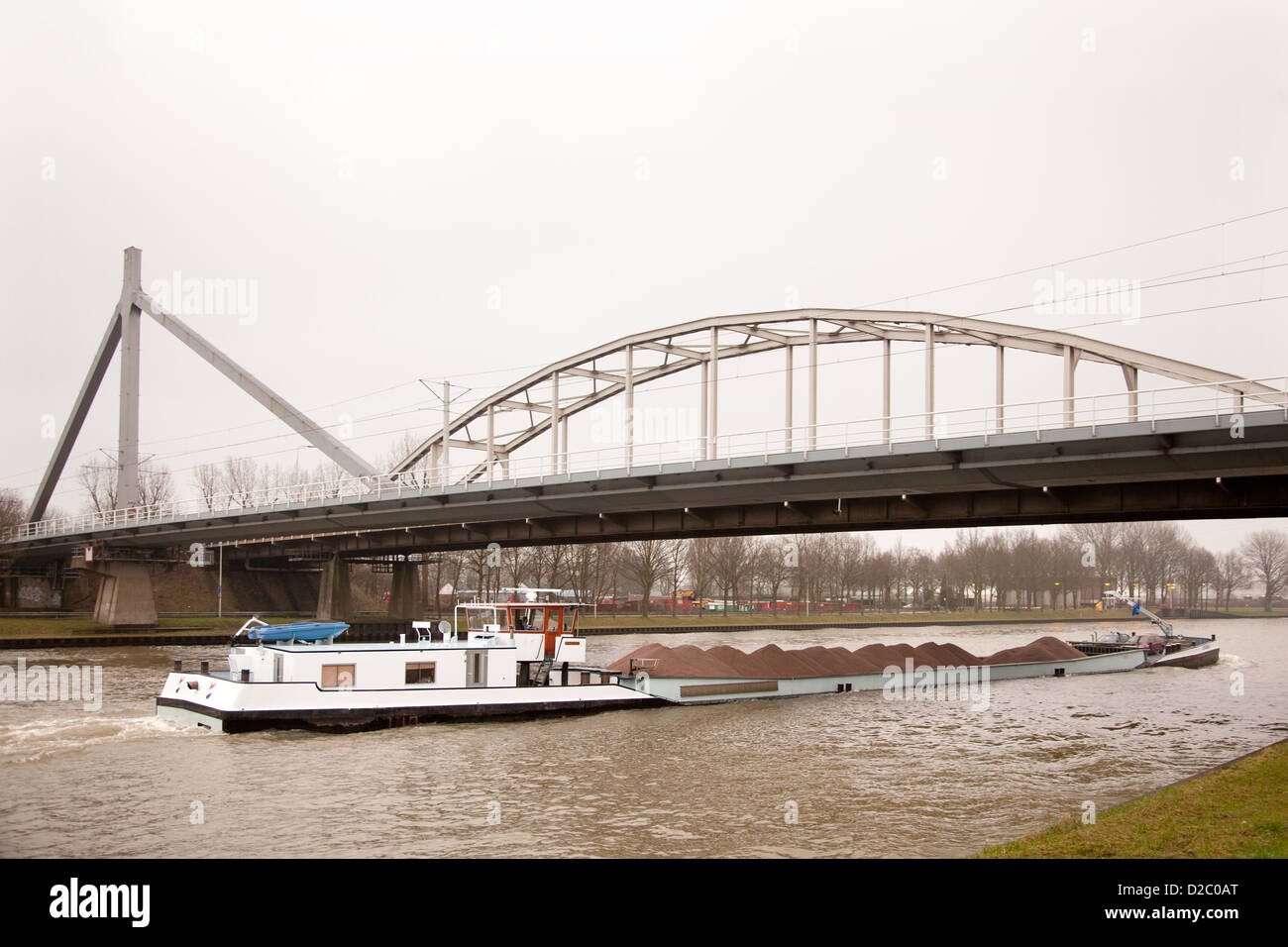 das Schiff im Kanal den Transport von Sand unter Brücke in den Niederlanden Stockfoto