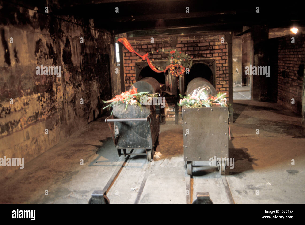 Polen, Auschwitz. Wagen für das Laden von Leichen ins Krematorium. Öfen im Hintergrund. Stockfoto