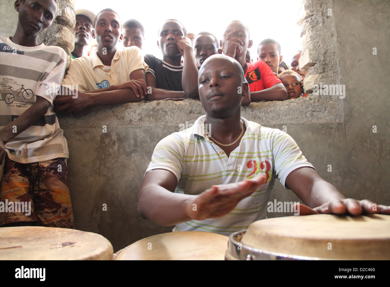 Eric mwangi von katebul auf Percussion Proben für den Lake Turkana Festival als lokale Kinder schauen auf Stockfoto