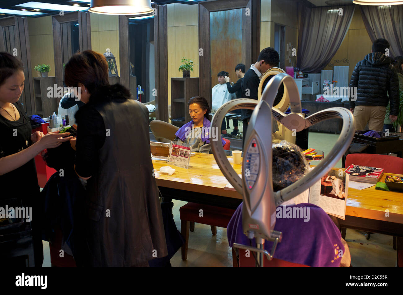 Chinesische Damen bekommen ihre Haare Behandlung in einem hochwertigen Friseursalon in Peking, China.12 Jan 2013 Stockfoto