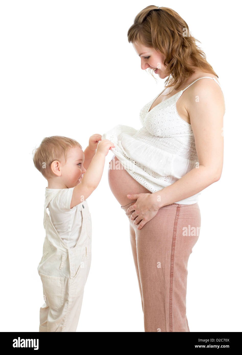 Kleiner Junge Blick in den Bauch der schwangeren Mutter Stockfoto