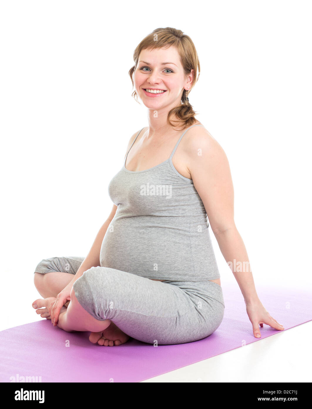 Schwangere Frau gymnastische Übungen isoliert auf weiss Stockfoto