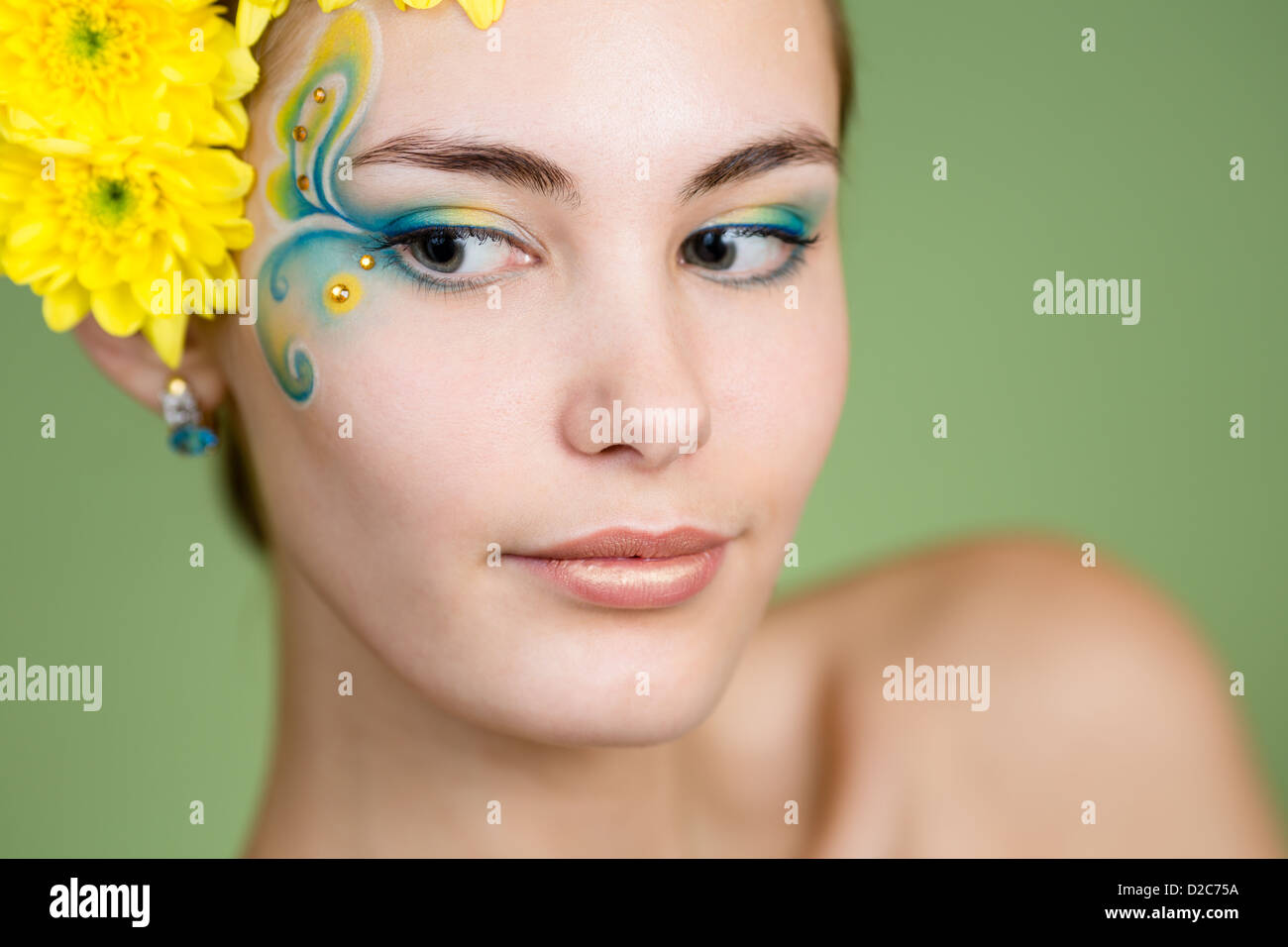 Junges Mädchen Modell mit Fantasie Make-up und Chrysanthemen Blumen im Haar Stockfoto
