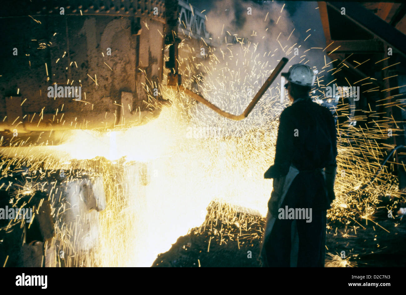 Indien. Arbeiter im Stahlwerk, Silhouette durch glühende Funken Stockfoto