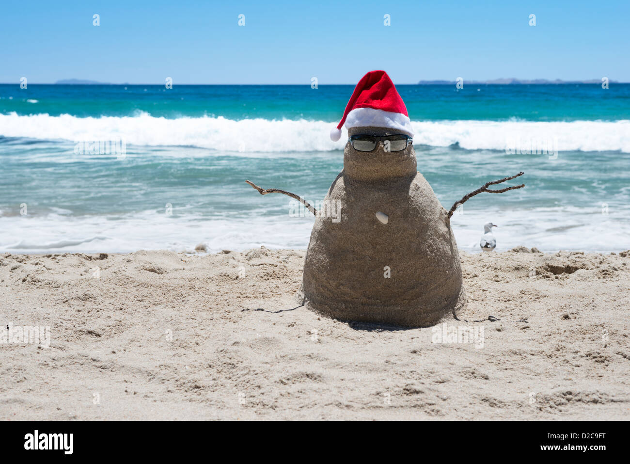 Eine Sandburg Santa tragen einen roten Weihnachten Santa Hut und Sonnenbrille am Strand im Sommer Stockfoto