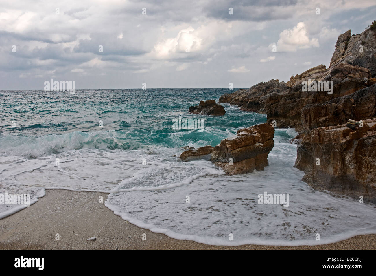 Wellen brechen sich am felsigen Strand Stockfoto