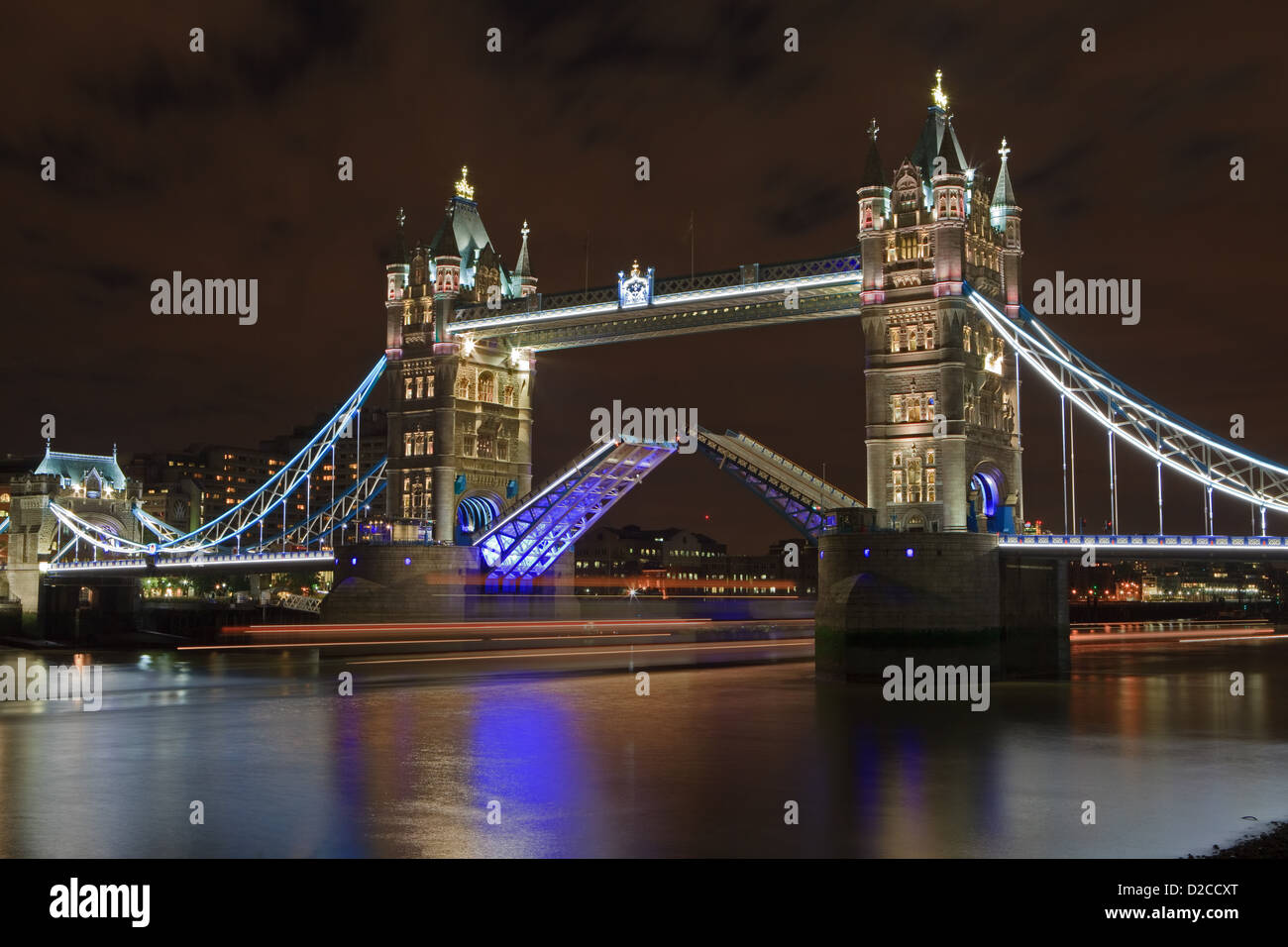 Dies ist ein Bild der Tower Bridge für den nautischen Verkehr passieren, können Sie die Lichtspuren eines Bootes sehen, wie es geht. Stockfoto