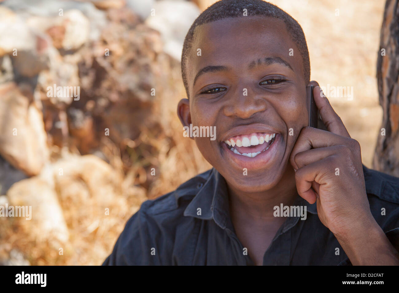 Junge afrikanische Mann auf Handy Stockfoto