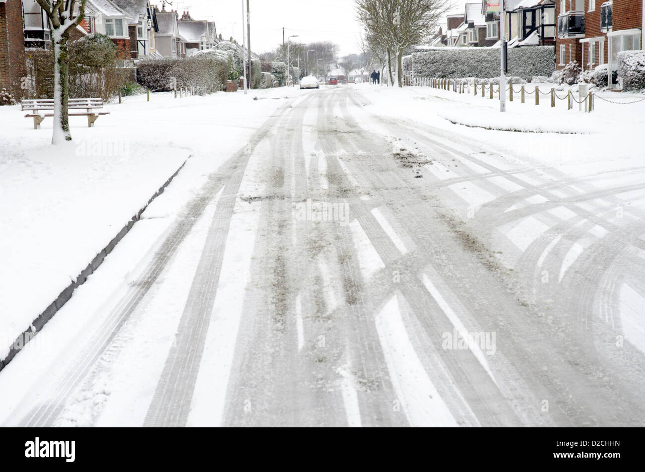 Straße bedeckt im Schnee mit Reifenspuren nach einem Schneefall. Stockfoto