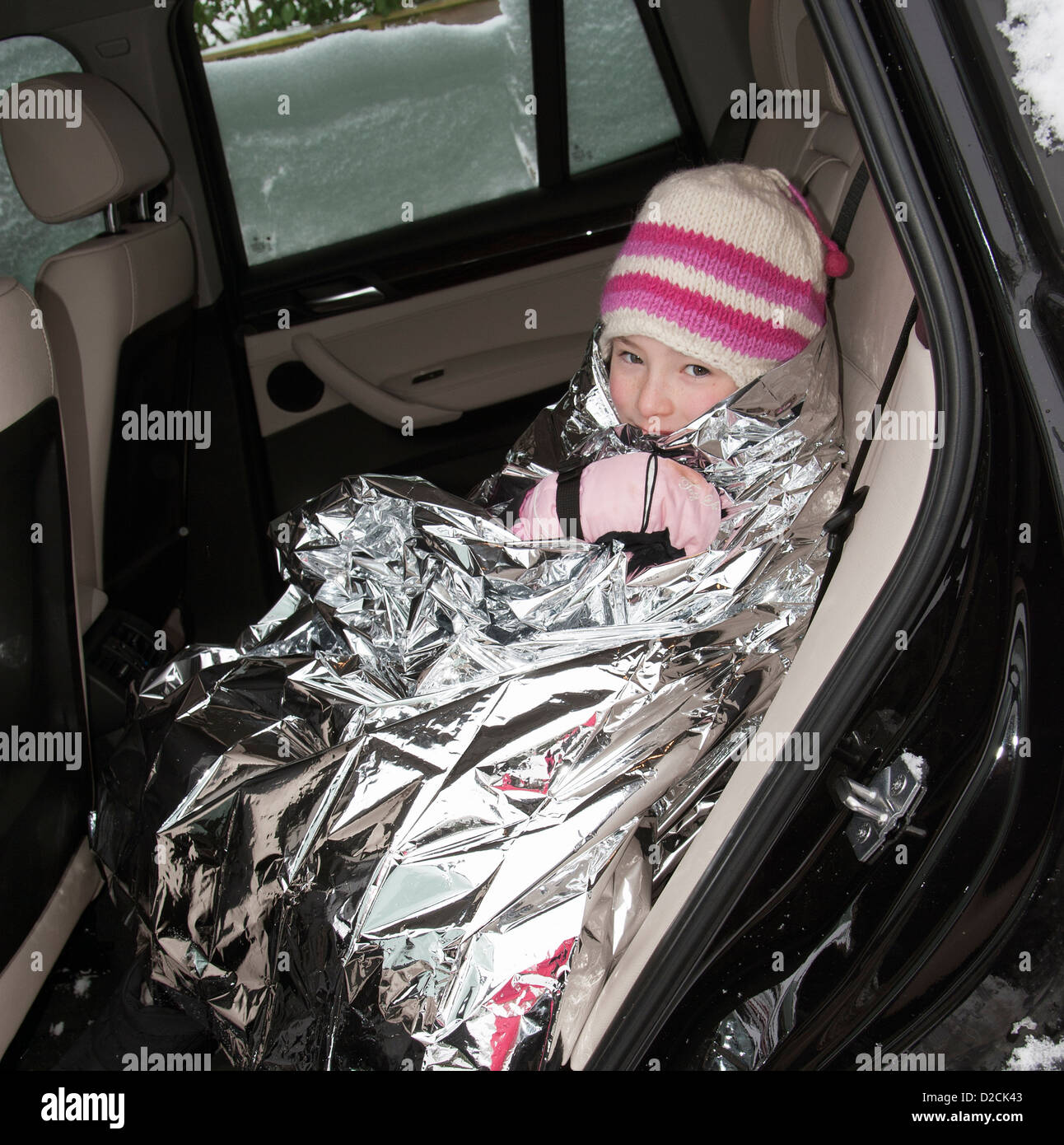 Junges Mädchen in eine Folie Decke Warmhalten in einem Auto Winter Wetter  Kälteeinbruch gewickelt Stockfotografie - Alamy