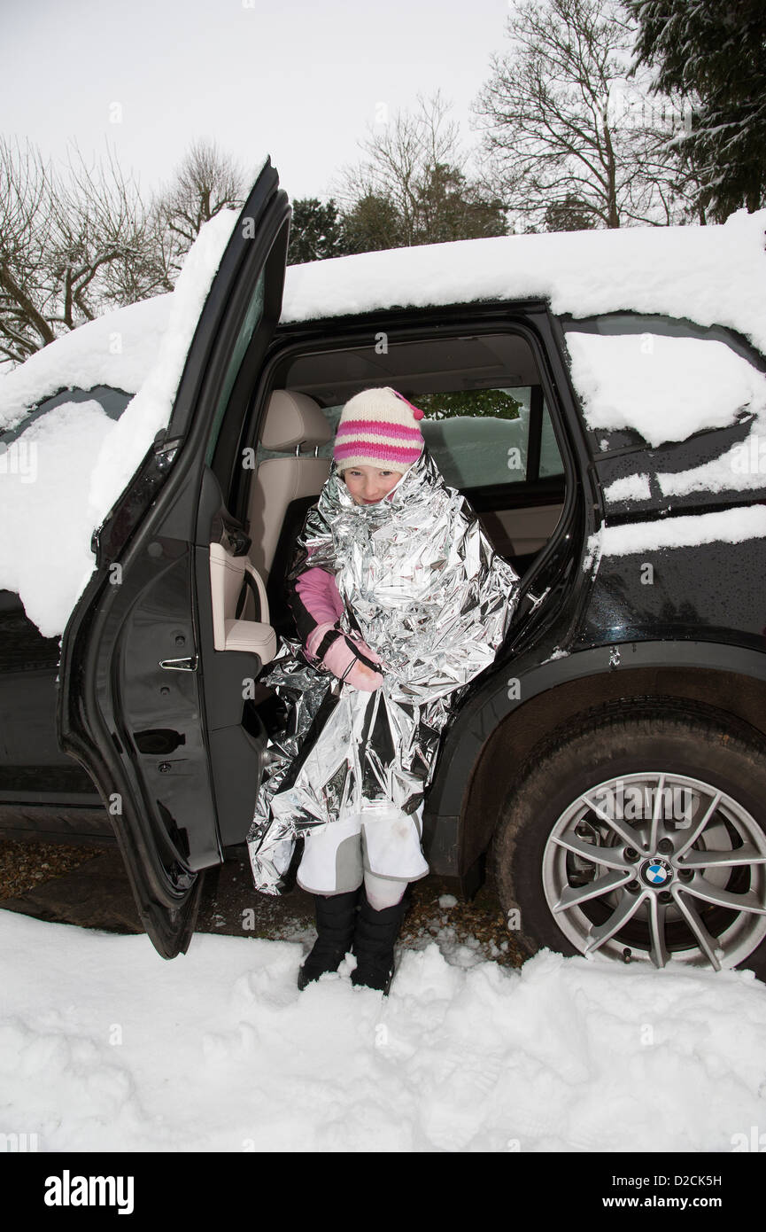 Junges Mädchen in eine Folie Decke Warmhalten in einem Auto Winter