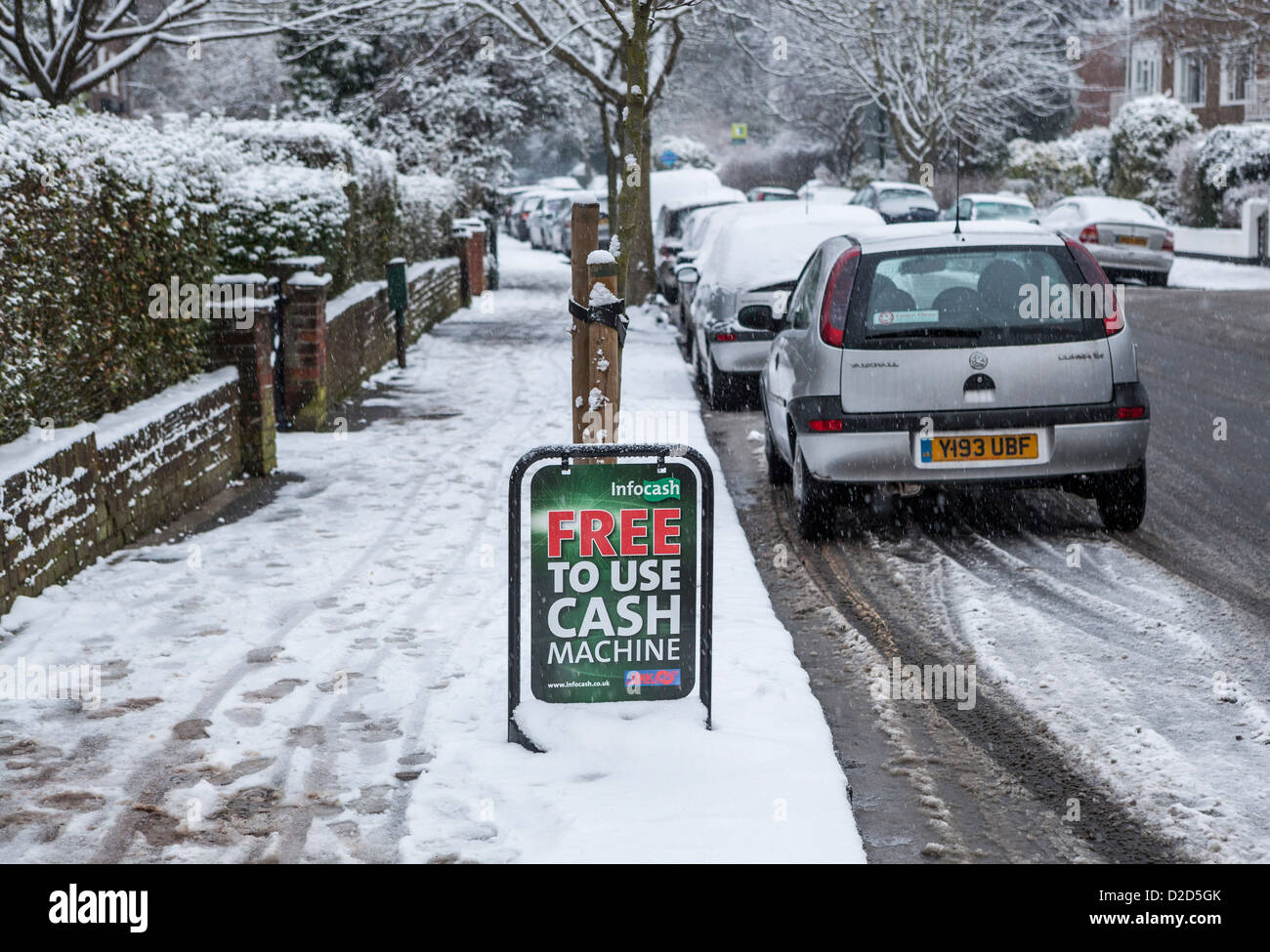 Ein Advertisemnet für ein "frei zu verwenden" Geldautomat im Schnee bedeckt s Straße - Strawberry Hill, Twickenham, Großbritannien Stockfoto