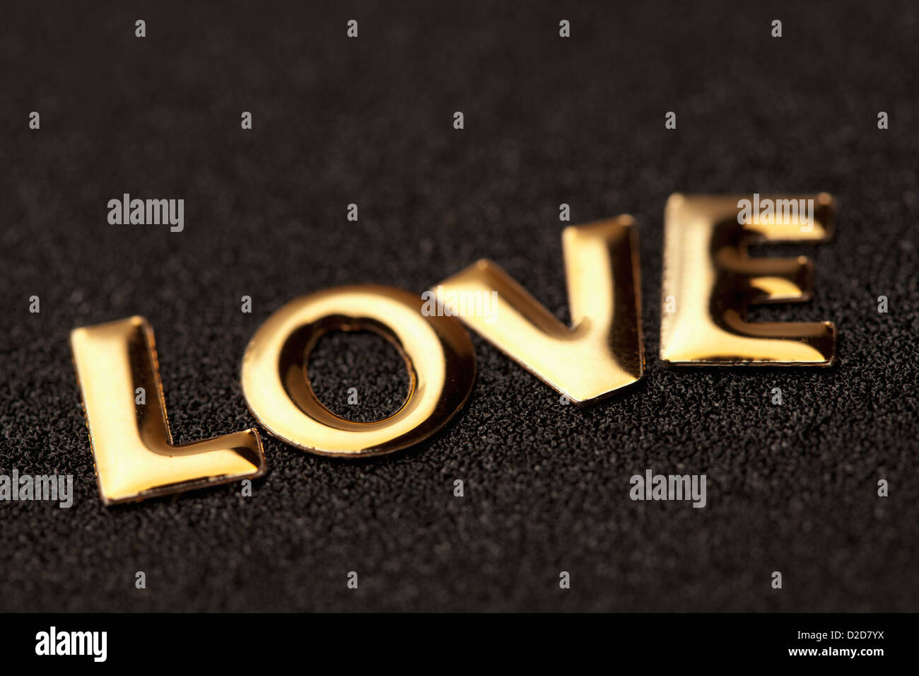 Einziges Wort 'Liebe' in goldenem Schriftzug Stockfoto
