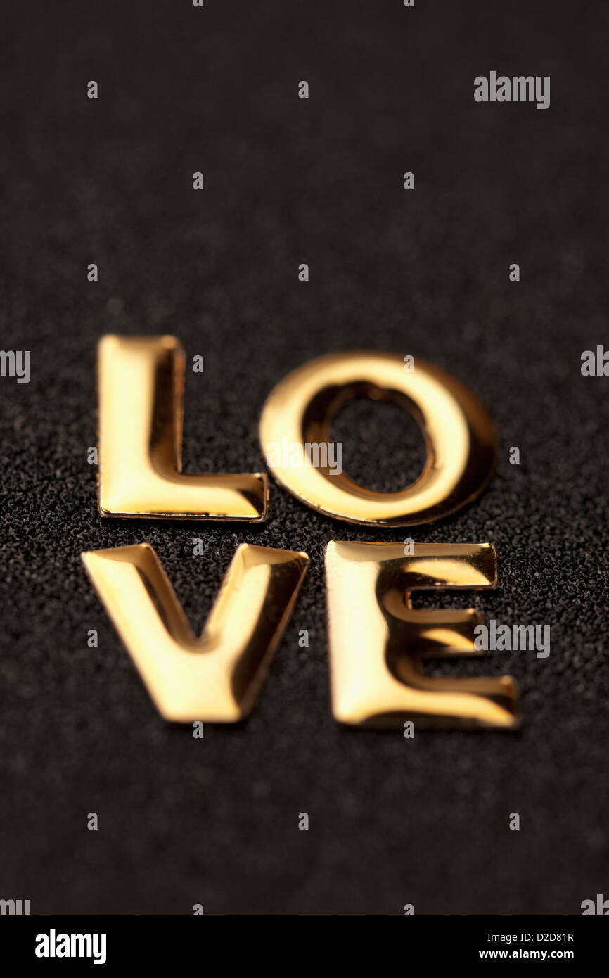 Einziges Wort 'Liebe' in goldenem Schriftzug Stockfoto