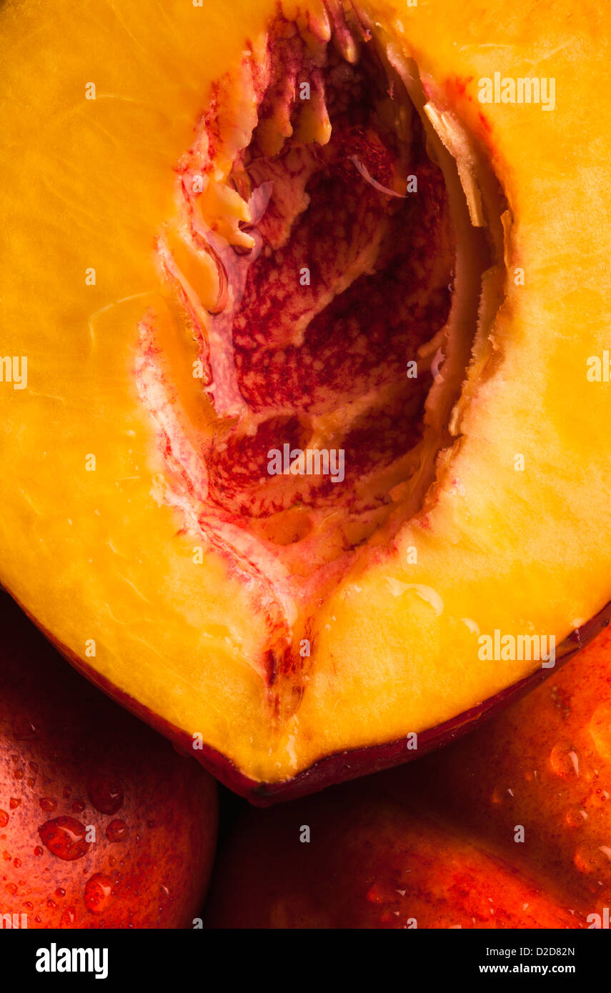Halbjahr ein saftiger Pfirsich ruht auf zwei ungeschnitten Pfirsiche, full-frame Stockfoto