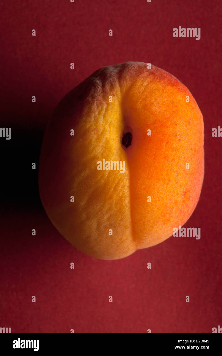 Ein leicht faltig Pfirsich auf rotem Grund Stockfoto